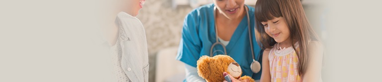 doctor giving a little girl a teddy bear