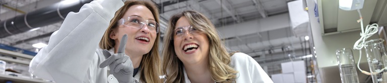 Two students looking at a beaker.