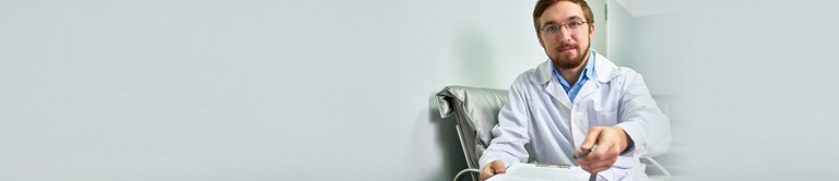 Man wearing lab coat handing the photographer an item